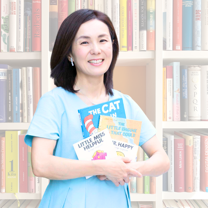 英語絵本を抱えてほほえむ、Read&Talk主宰のトコさん